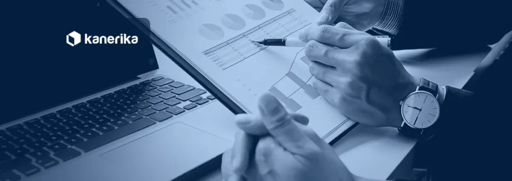 Two finance professionals reviewing charts and reports on paper next to a laptop, a blue-toned photo for an article on RPA in finance